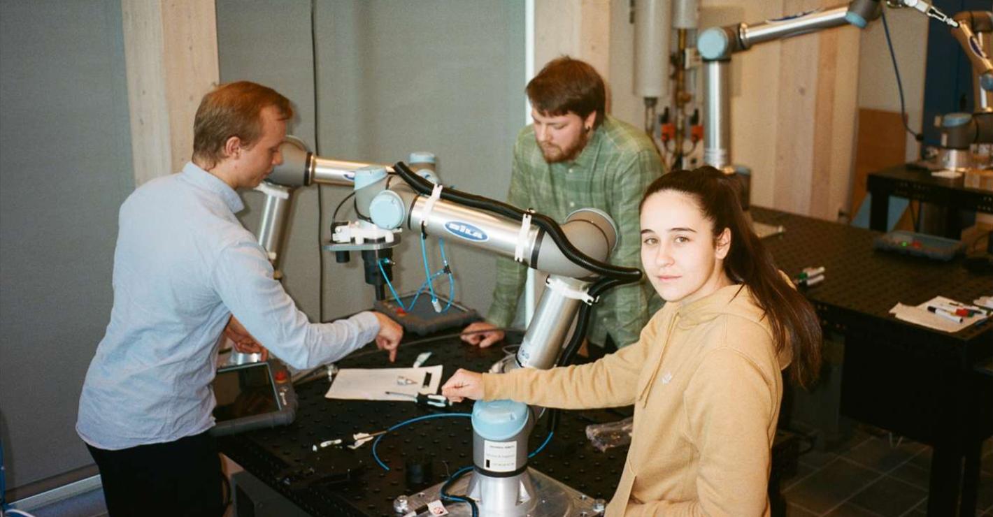Studerende ved en robotarm