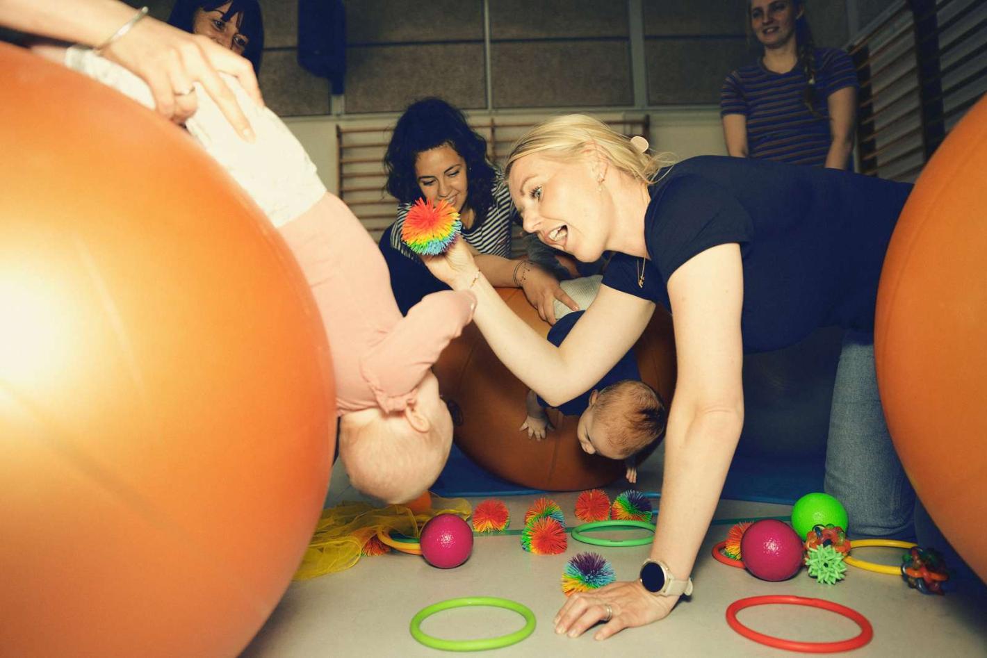 Monica laver øvelser med et barn på en stor bold