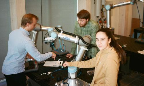 Studerende ved en robotarm